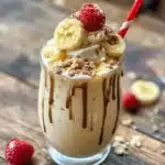 Delicious homemade Banana Split Milkshakes topped with whipped cream and cherries.