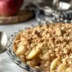 Delicious Ina Garten's apple crisp served in a rustic dish with a scoop of ice cream