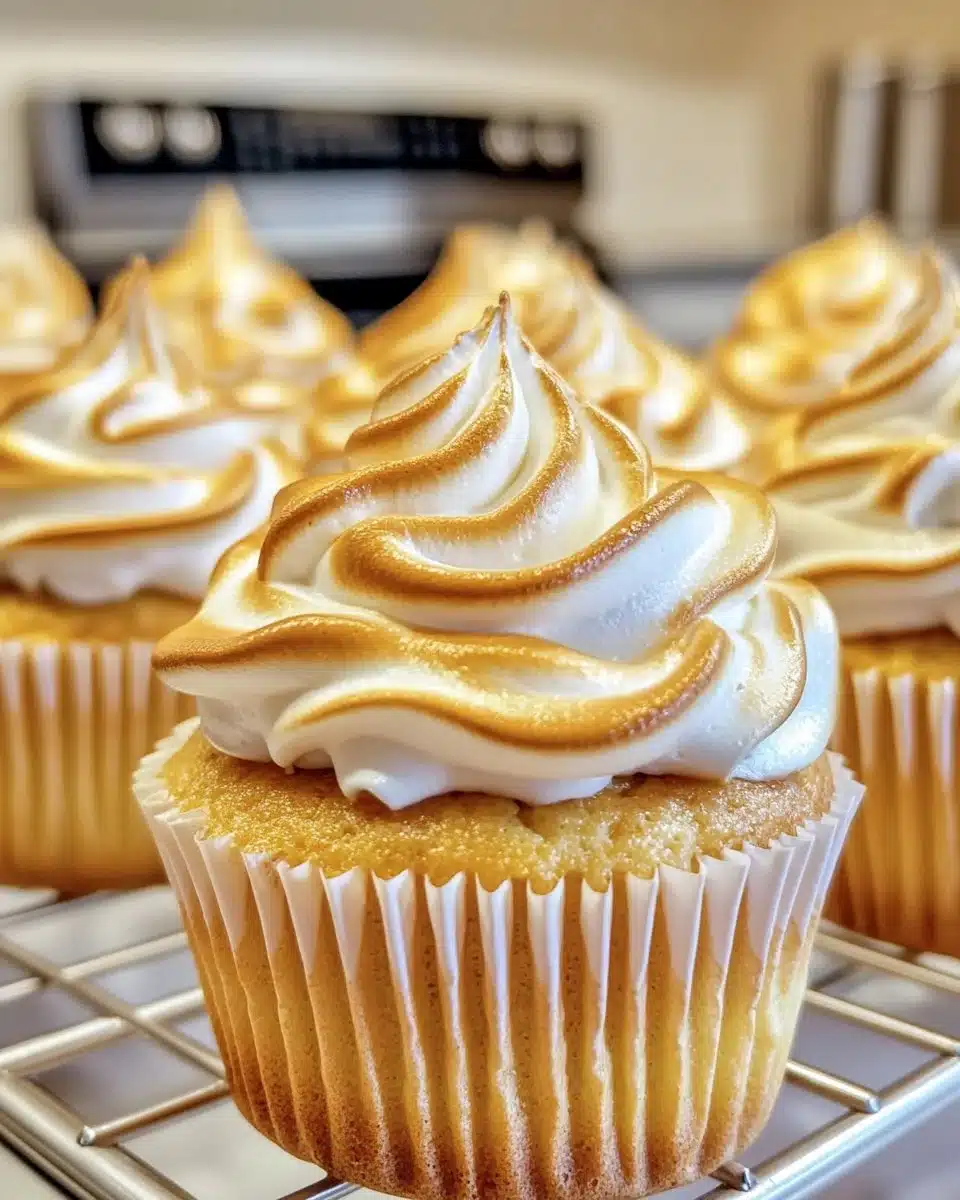 Lemon meringue cupcakes topped with fluffy meringue and lemon zest